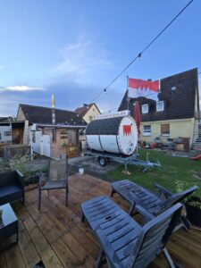 Fasssauna am Abend im Garten aufgestellt