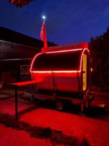 Fasssauna bei Nacht mit stimmungsvoller roter LED-Beleuchtung